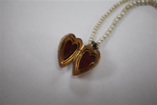An early 20th century gold, ruby and split pearl set heart shaped pendant locket, pendant inc. bale 1in.